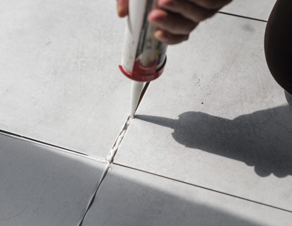 Grout being applied between ceramic floor tiles during installation.