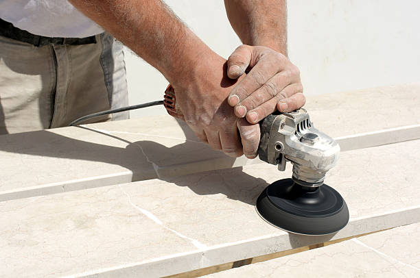 Worker polishes repaired marble tiles with the sander.