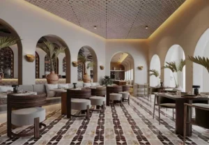Elegant restaurant interior with patterned floor tiles, arched architecture, dark wood furniture and warm ambient lighting.